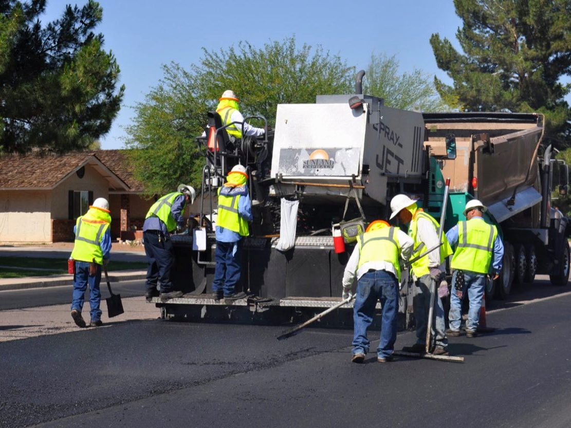 Asphalt crew at work resurfacing a street